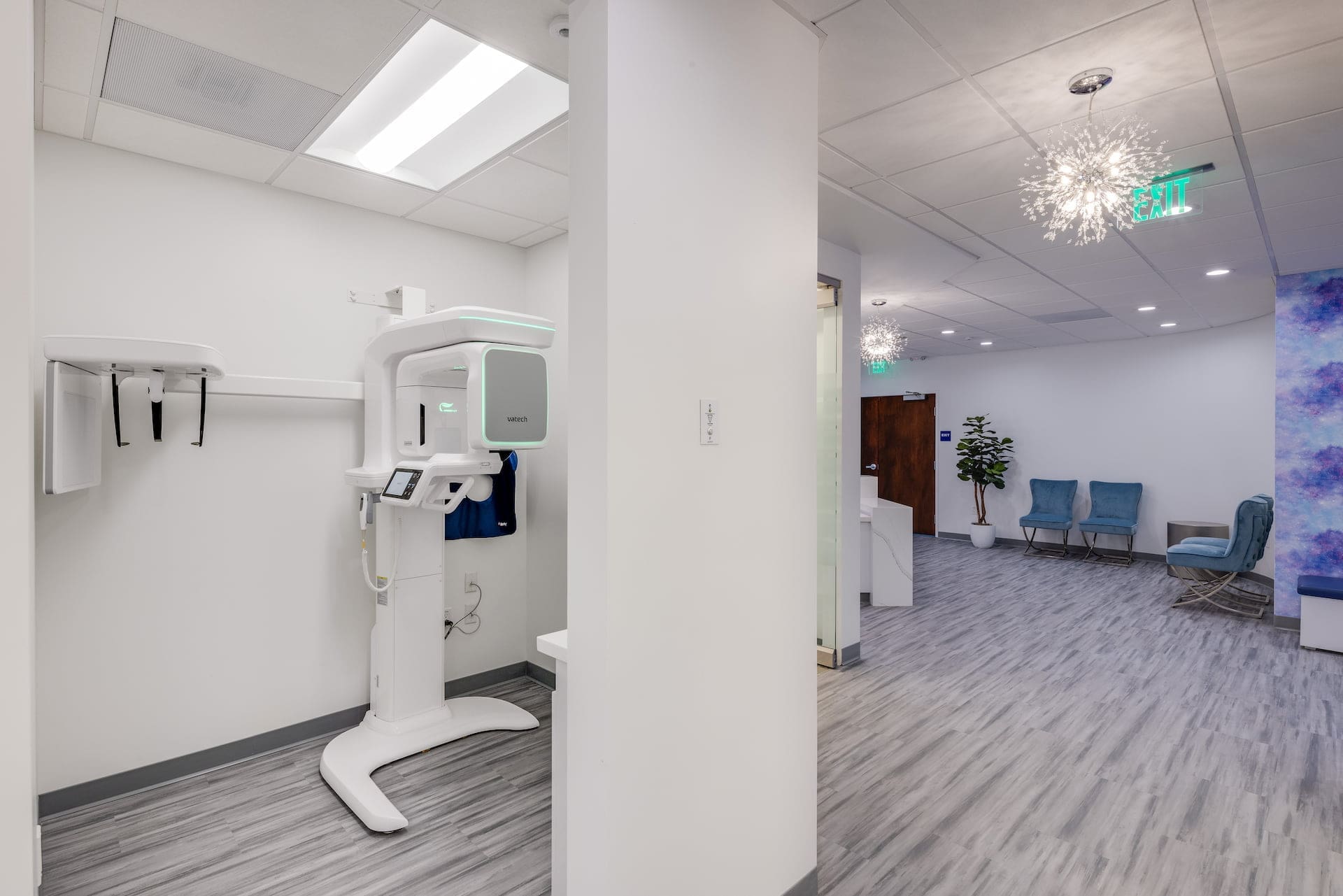 Stellar Orthodontics in San Marcos, CA features a modern dental office equipped with a panoramic X-ray machine and a stylish waiting area with blue chairs and decorative lighting for braces treatments.