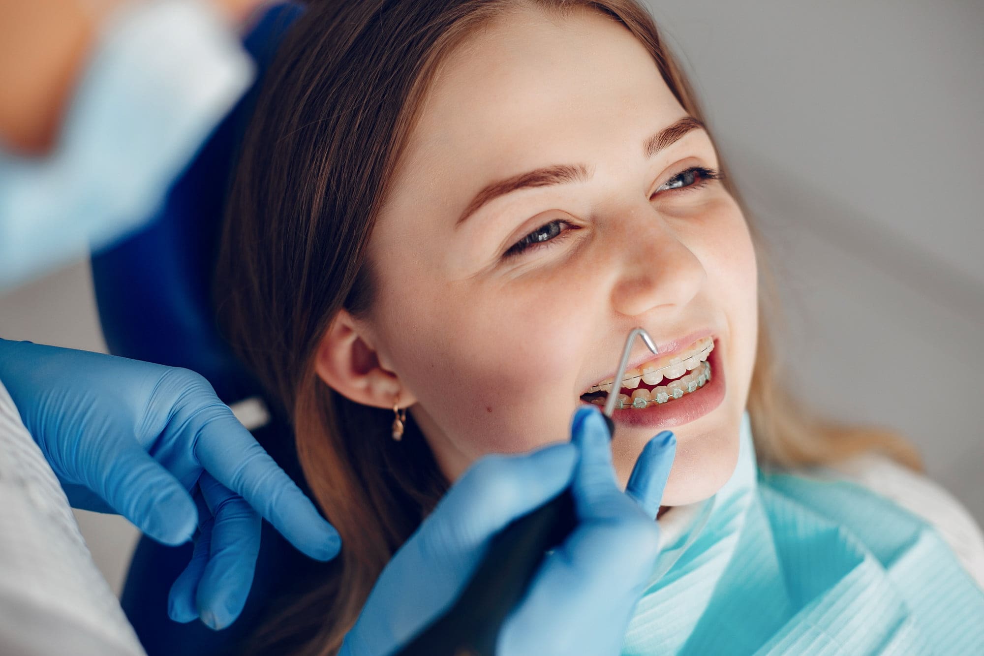 A woman undergoing a dental examination by a dentist in San Marcos CA, focusing on her teeth and palatal expander